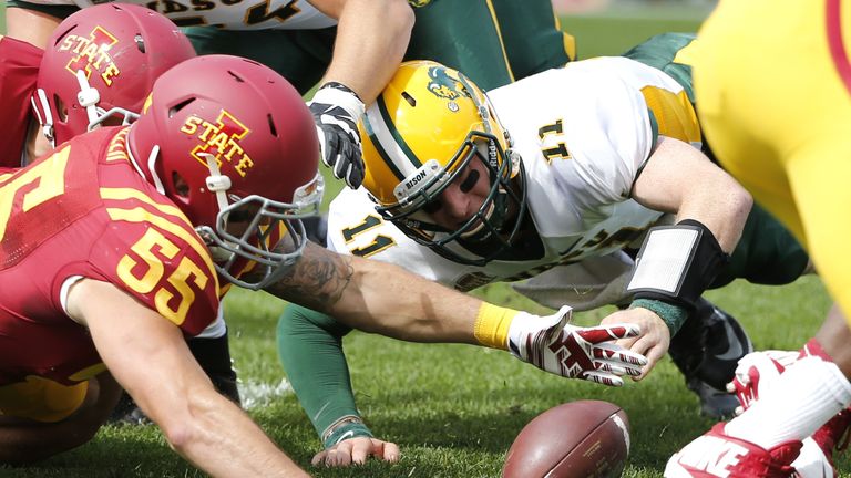 Carson Wentz #11 of the North Dakota State Bison fights to recover a fumble with linebacker Jevohn Miller #55 of the Iowa