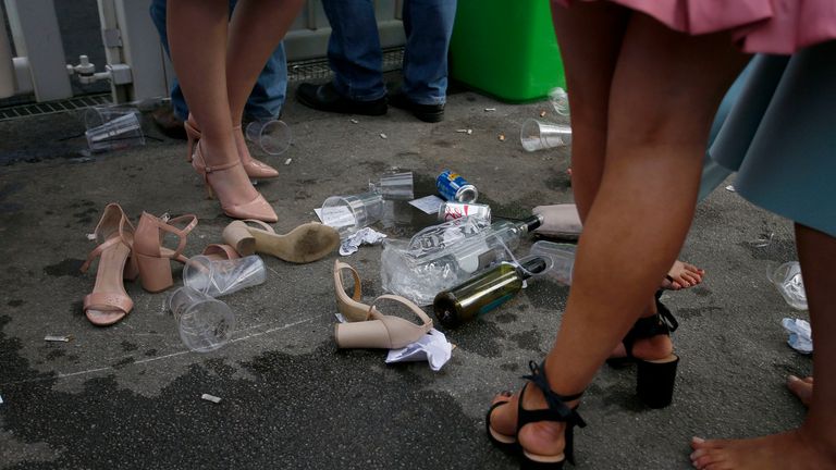 Empty bottles and cups lie amongst shoes