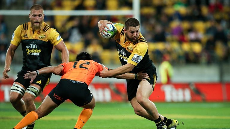 Dane Coles of the Hurricanes (R) is tackled by Santiago Gonzalez Iglesias