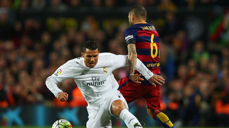 Cristiano Ronaldo of Real Madrid CF is brought down by Daniel Alves of FC Barcelona
