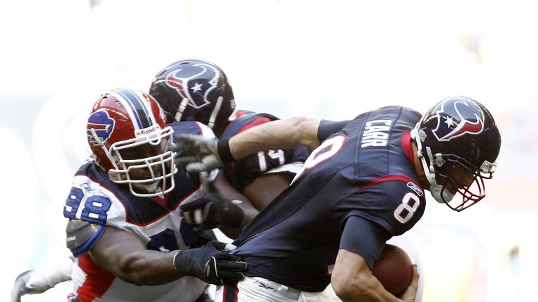 Houston Texans quarterback David Carr (8) eludes the grasp of Buffalo Bills defensive tackle Larry Tripplett (98) as he scrambles out of the pocket during 