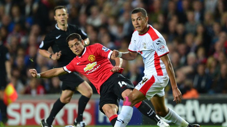 Dele Alli, playing for MK Dons, challenges Manchester United's Javier Hernandez during the Capital One Cup second round in August, 2014.
