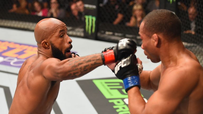 Demetrious Johnson punches John Dodson in their flyweight championship bout during the UFC 191
