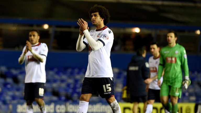 Derik Osede applauds Bolton's travelling fans after 1-0 defeat to Birmingham in February