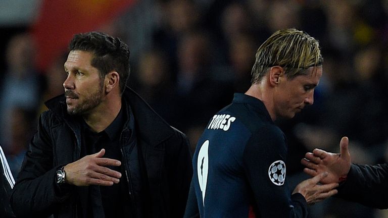 Atletico Madrid's forward Fernando Torres (R) passes by Atletico Madrid's Argentinian coach Diego Simeone as he leaves the pitch after b