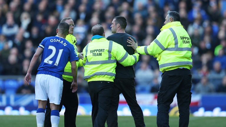 Everton support team carry off a pitch invaider during the Barclays Premier League match between Everton and Southampton at