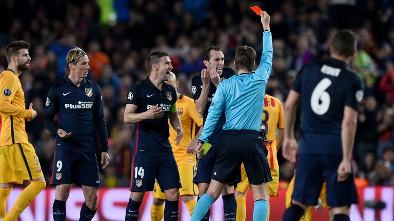 Felix Brych (C) shows a red card to Atletico Madrid's Fernando Torres (2L) as Atletico Madrid's defender Diego Godin and Atletico Madrid's midfielder Gabi