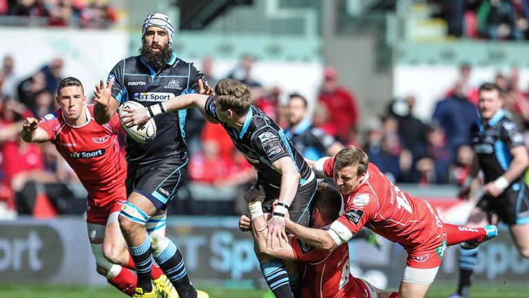 Glasgow Warriors' Finn Russell offloads despite the tackle of Scarlets' Hadleigh Parkes