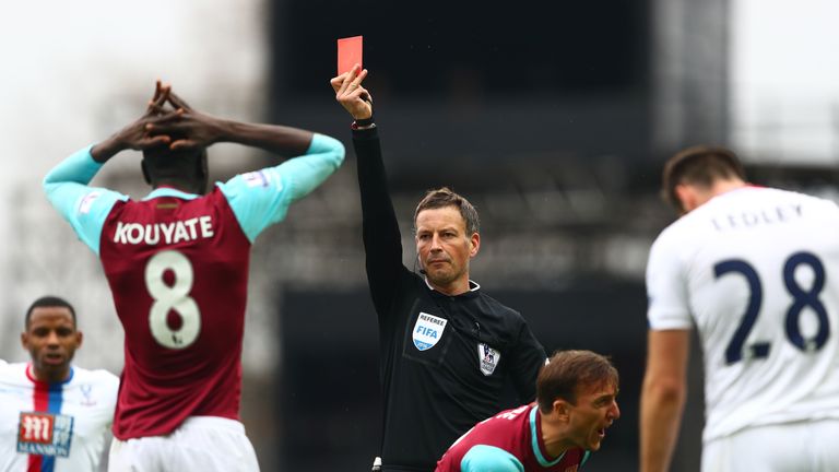 Cheikhou Kouyate of West Ham is shown a red card by referee Mark Clattenburg