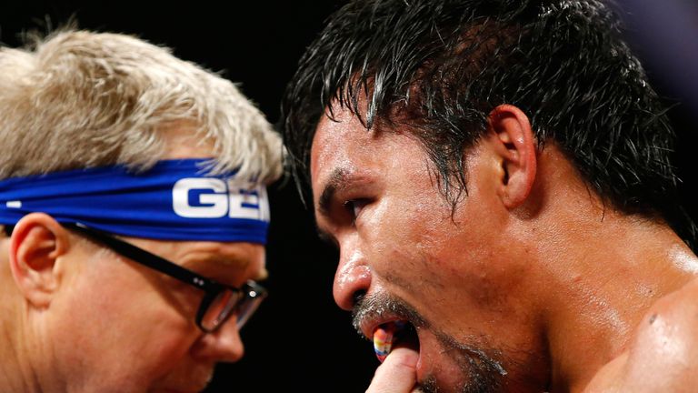 Trainer Freddie Roach adjust Manny Pacquiao's mouth guard 