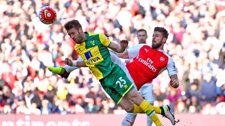 Ivo Pinto of Norwich City clears the ball in front of Olivier Giroud of Arsenal during the Premier League match at the Emirates