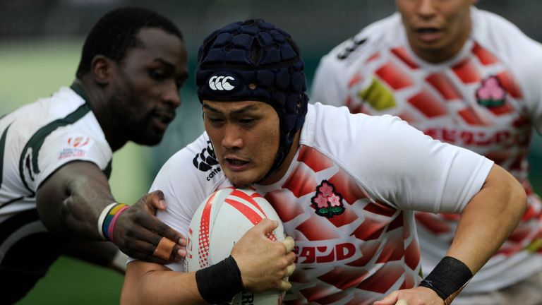 Masakatsu Hikosaka (C) of Japan breaks the defence of Zimbabwe on the third day of the Hong Kong Rugby Sevens tournament in Hong Kong