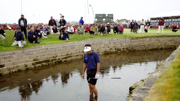 Jean Van De Velde looks at his ball in the burn on the 18th hole during the British Open 