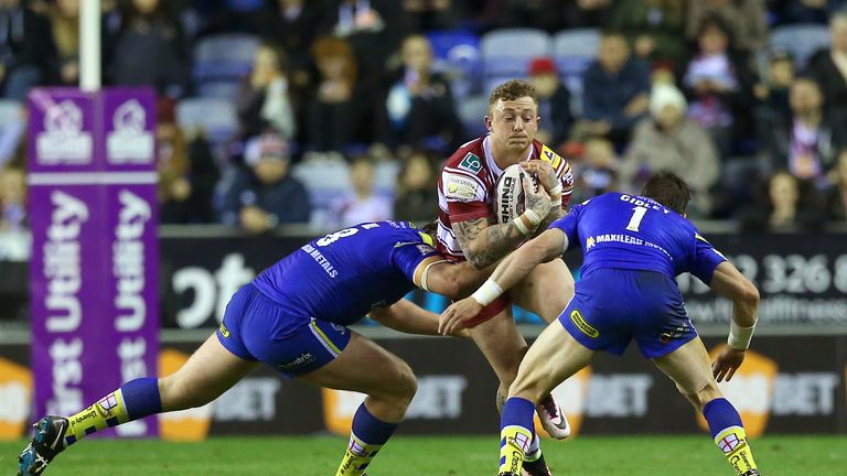 Wigan Warriors Josh Charnley is tackled by Warrington Wolves' Chris Hill (left) and Kurt Gidley (right)