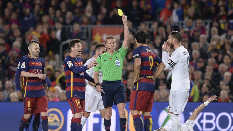 Barcelona's Uruguayan forward Luis Suarez (2R) is handed a yellow card