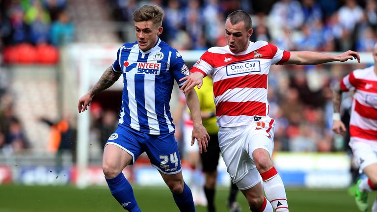 Luke McCullough (R) of Doncaster Rovers challenges Conor McAleny of Wigan Athletic