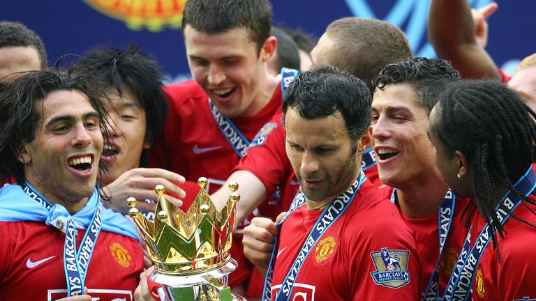 Manchester United's Welsh midfielder Ryan Giggs looks at the English Premier League trophy after Manchester United beat Wigan Athletic at The JJB Stadium i