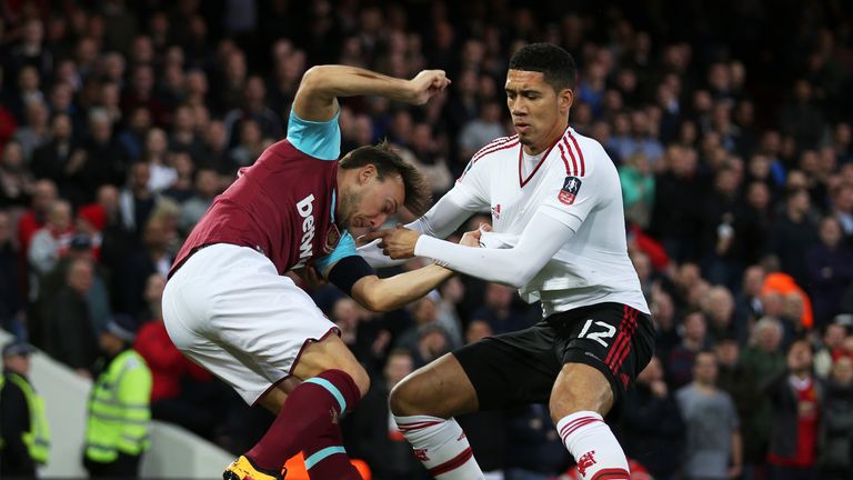 Mark Noble of West Ham United is challenged by Chris Smalling of Manchester United 