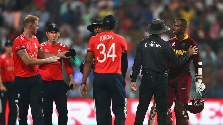 Marlon Samuels of the West Indies is spoken to by the umpires after he celebrates victory over England