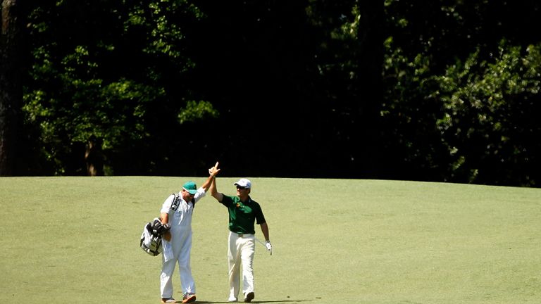 Louis Oosthuizen (L) of South Africa celebrates with his caddie Wynand Stander after making an albatross on the second hole 