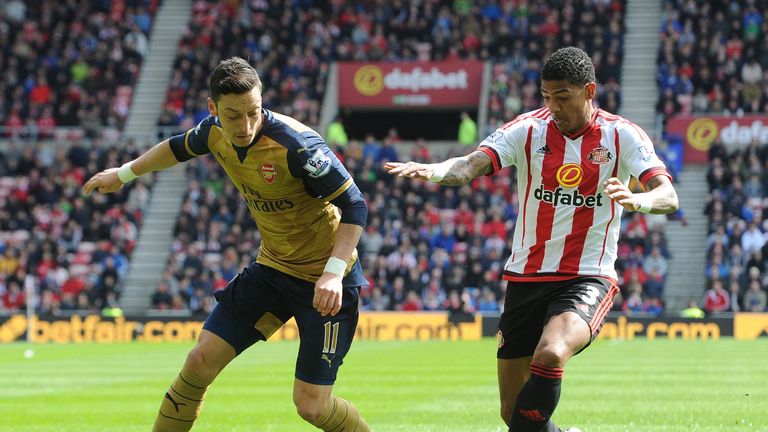 Mesut Ozil is closed down by Patrick van Aanholt 