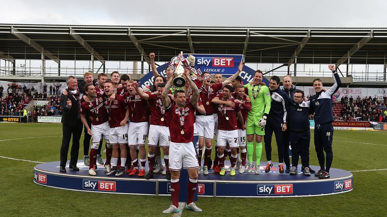 Northampton Town players celebrate after receiving the Sky Bet League Two champions trophy after 2-0 win over Luton Town