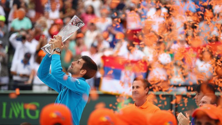 Novak Djokovic holds aloft the Butch Buchholz trophy after his straight sets victory against Kei Nishikori in the Miami Open final