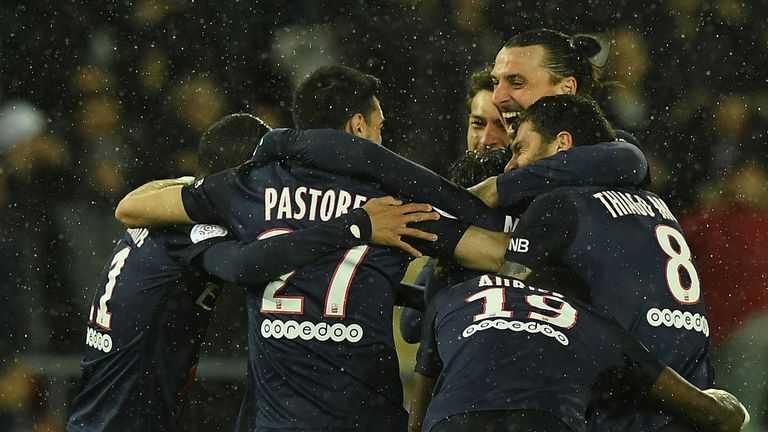 Paris Saint-Germain's Brazilian defender Maxwell (hidden) is congratulated by teammates after scoring a goal during 