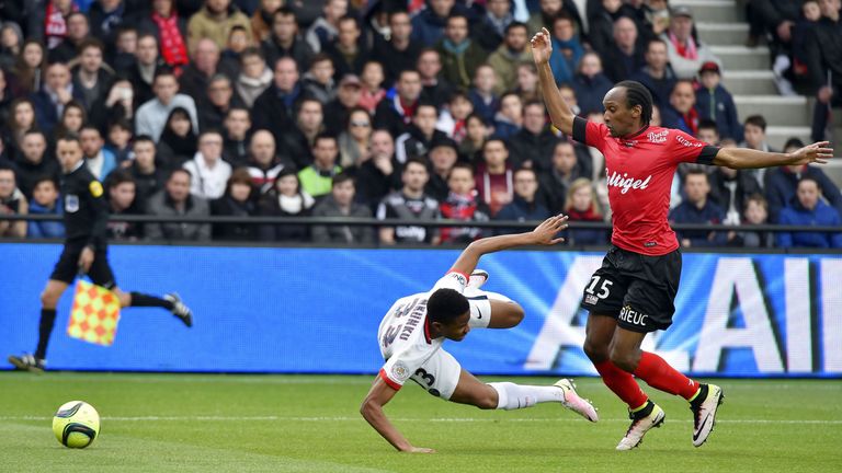 Guingamp's Jeremy Sorbon (R) trips Christopher Alan Nkunku to hand PSG a penalty