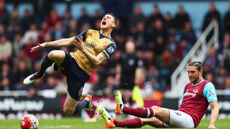 Laurent Koscielny of Arsenal is tackled by Andy Carroll of West Ham United during the Barclays Premier League match between Arsenal and West Ham