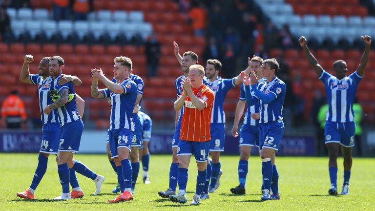 Wigan Athletic players celebrate promotion to the Championship after the Sky Bet League One match between Blackpool and Wigan