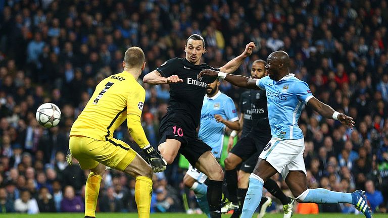 Zlatan Ibrahimovic of Paris Saint-Germain beats Eliaquim Mangala (20) and Joe Hart of Manchester City to score, but his goal is disallowed