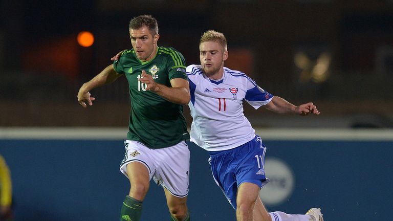Aaron Hughes (L) holds off Pall Klettskard off the Faroe Islands during a Euro 2016 qualifier 