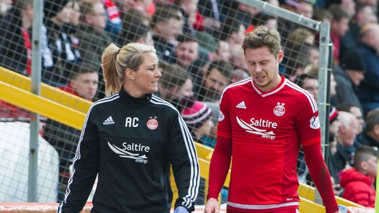 Aberdeen's Simon Church (right) leaves the park after picking up an injury