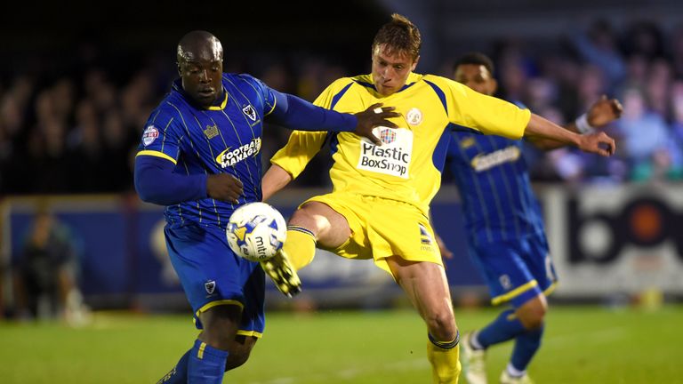 AFC Wimbledon's Adebayo Akinfenwa (left) and Accrington Stanley's Tom Davies battle for possession