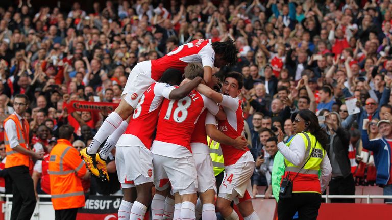 Arsenal players mob Arsenal's Spanish midfielder Mikel Arteta as he celebrates scoring his team's fourth goal during the English Premier League football ma