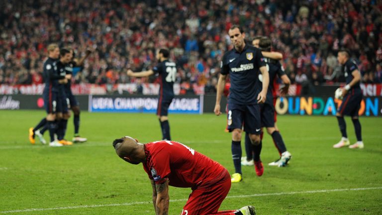 Arturo Vidal of Bayern Munich looks dejected as Atletico Madrid players celebrate after the UEFA Champions League semi final second leg match