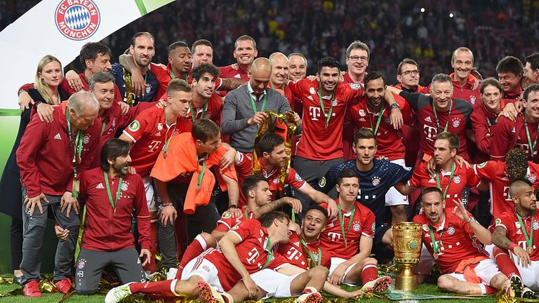 Bayern Munich's players and Bayern Munich's Spanish head coach Pep Guardiola celebrate with the trophy 