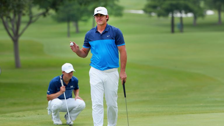 Brooks Koepka waves to the gallery as Jordan Spieth lines up a putt on the eighth green during the Final Round at AT&T Byron Nelson