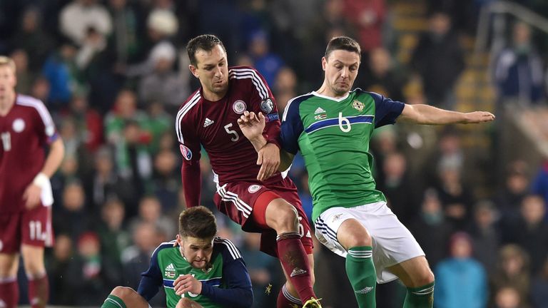 Oliver Norwood (L) and Chris Baird (R) of Northern Ireland tangle with Olegs Laizans of Latvia (C)