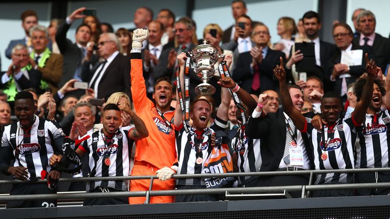 LONDON, ENGLAND - MAY 15: Grimsby's Craig Disley lifts the trophy as he celebrates the teams win and promotion to the football league during the Vanarama F