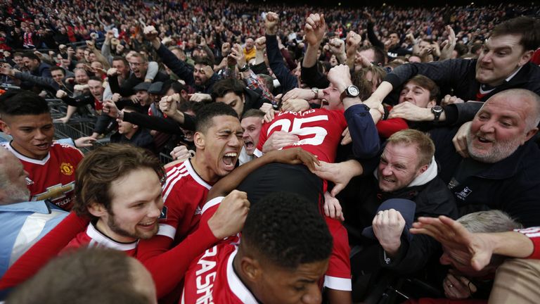 Manchester United players celebrate with the crowd including Manchester United's English midfielder Jesse Lingard (R), Manchester United's English defender
