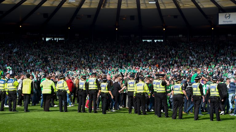 Police line the pitch after a fan invasion at Hampden Park