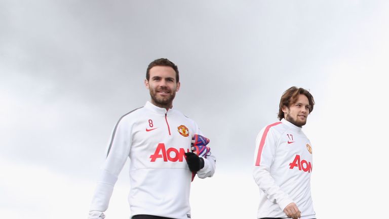 Juan Mata and Daley Blind of Manchester United walk out ahead of a first team training session at Aon Training Complex