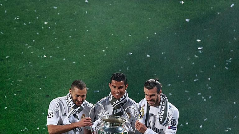 MADRID, SPAIN - MAY 29: Cristiano Ronaldo (2ndL) of Real Madrid CF holds the trophy as he poses for a picture with his teammates Karim Benzema (L) and Gare