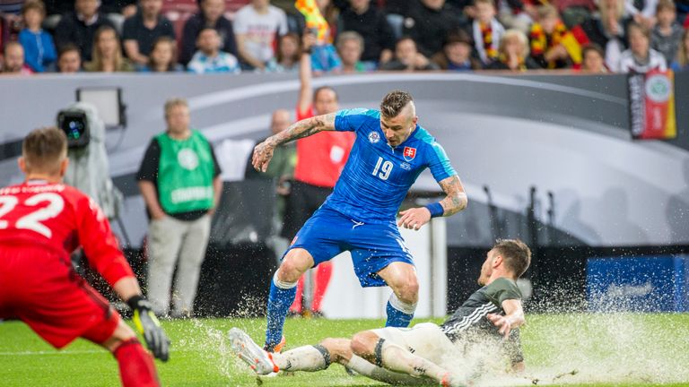 Jonas Hector (R) of Germany is challenged by Juraj Kucka of Slovakia during a storm-hit friendly