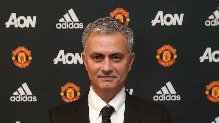Jose Mourinho poses with a Manchester United shirt after being confirmed as their new manager