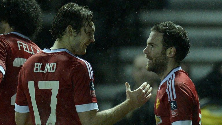 Manchester United's Dutch midfielder Daley Blind (L) congratulates Manchester United's Spanish midfielder Juan Mata