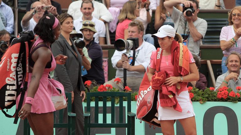 Belgian player Justine Henin (R) waits for US player Serena Williams as they leave the court after their French Tennis Open quarter final ma