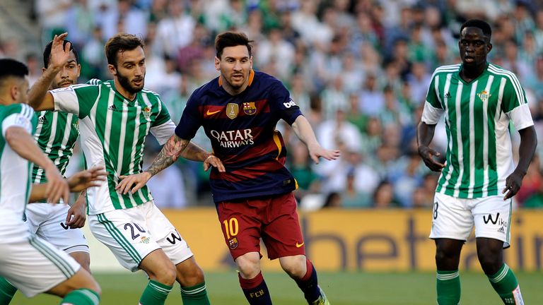 Lionel Messi (C) vies with Betis' German Pezzela 